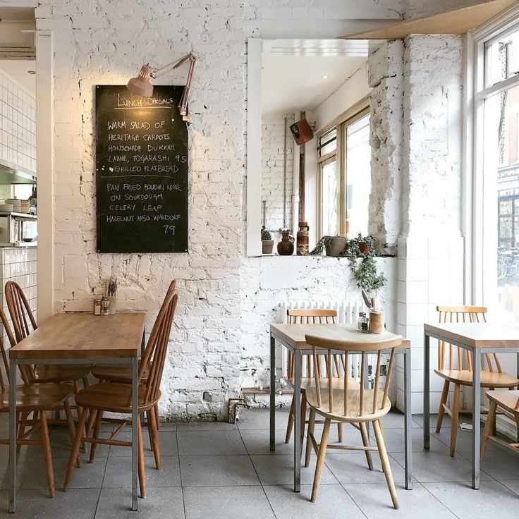 an empty restaurant with tables and chairs in front of a chalkboard on the wall