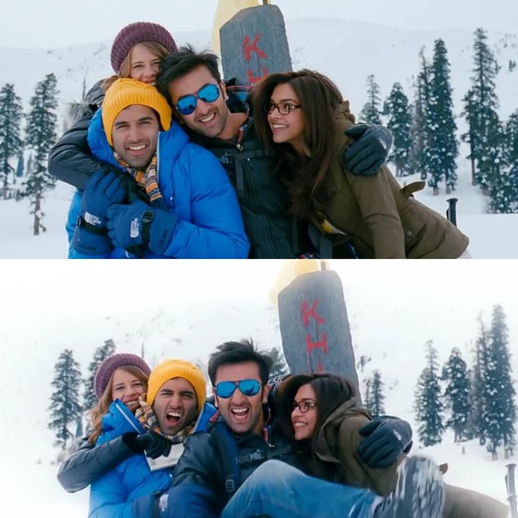 four people posing for a photo in the snow