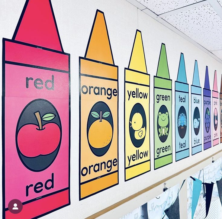 a row of colorful crayons hanging on the side of a wall in an elementary classroom