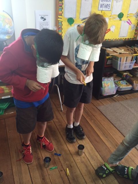 two children standing on the floor with their arms around each other and looking at something in front of them