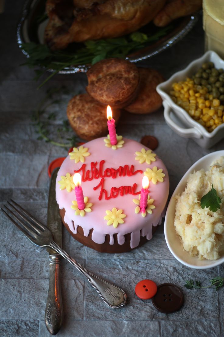 a birthday cake sitting on top of a table next to other foods and utensils