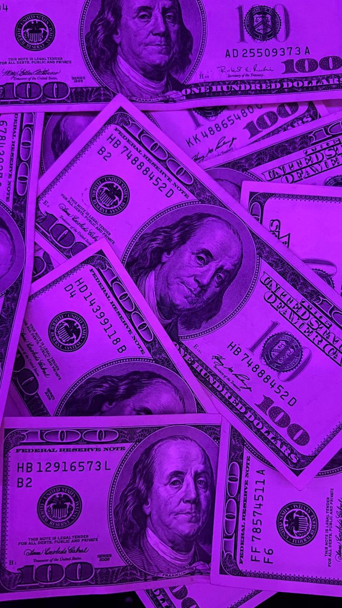 twenty dollar bills are shown in purple light