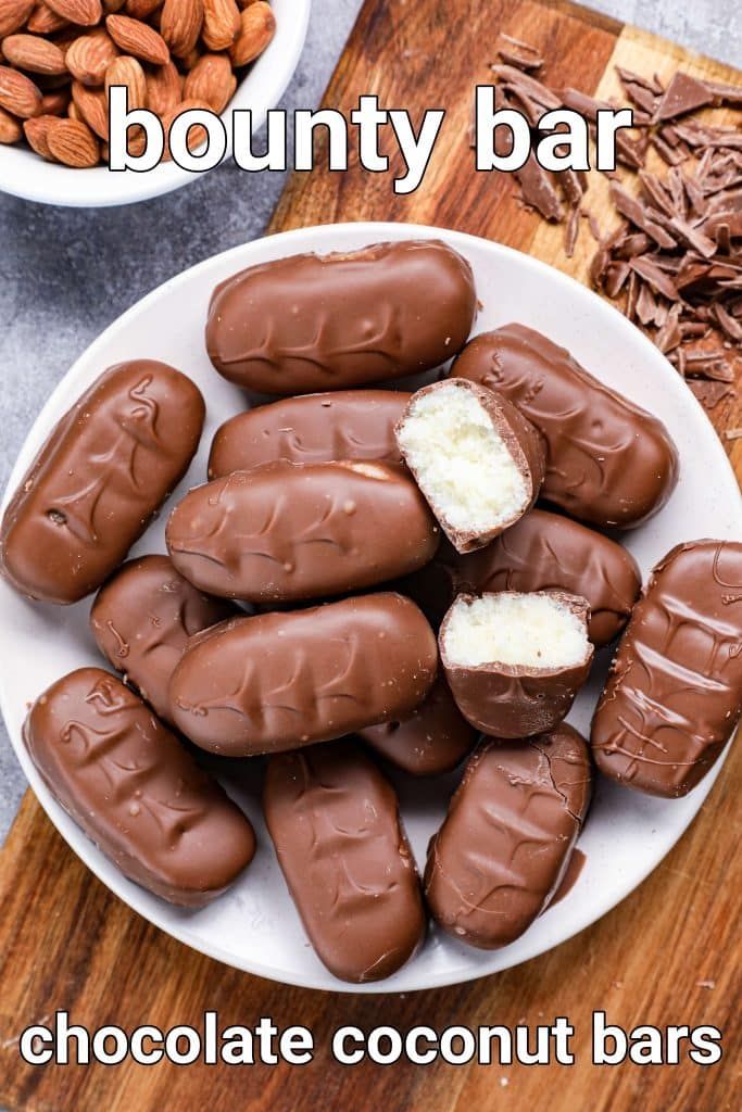 chocolate coconut bars on a white plate with almonds in the background and text overlay that reads, bounty bar