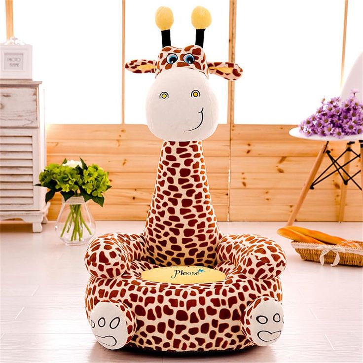 a giraffe shaped chair sitting on top of a white floor next to flowers