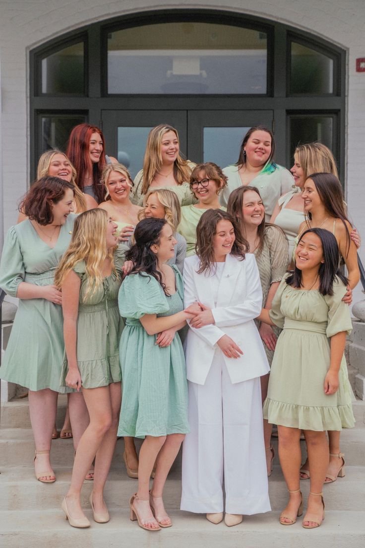 a group of women standing next to each other on steps in front of a building