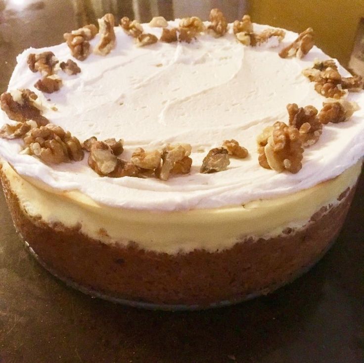 a cake with white frosting and walnuts on top