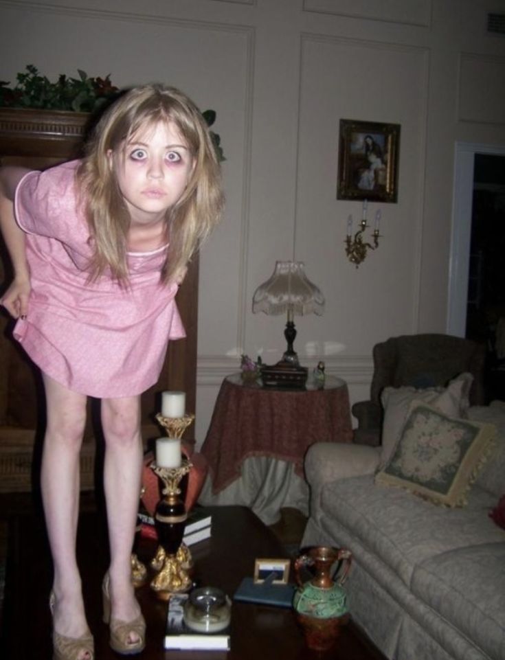 a woman standing on top of a table in a living room