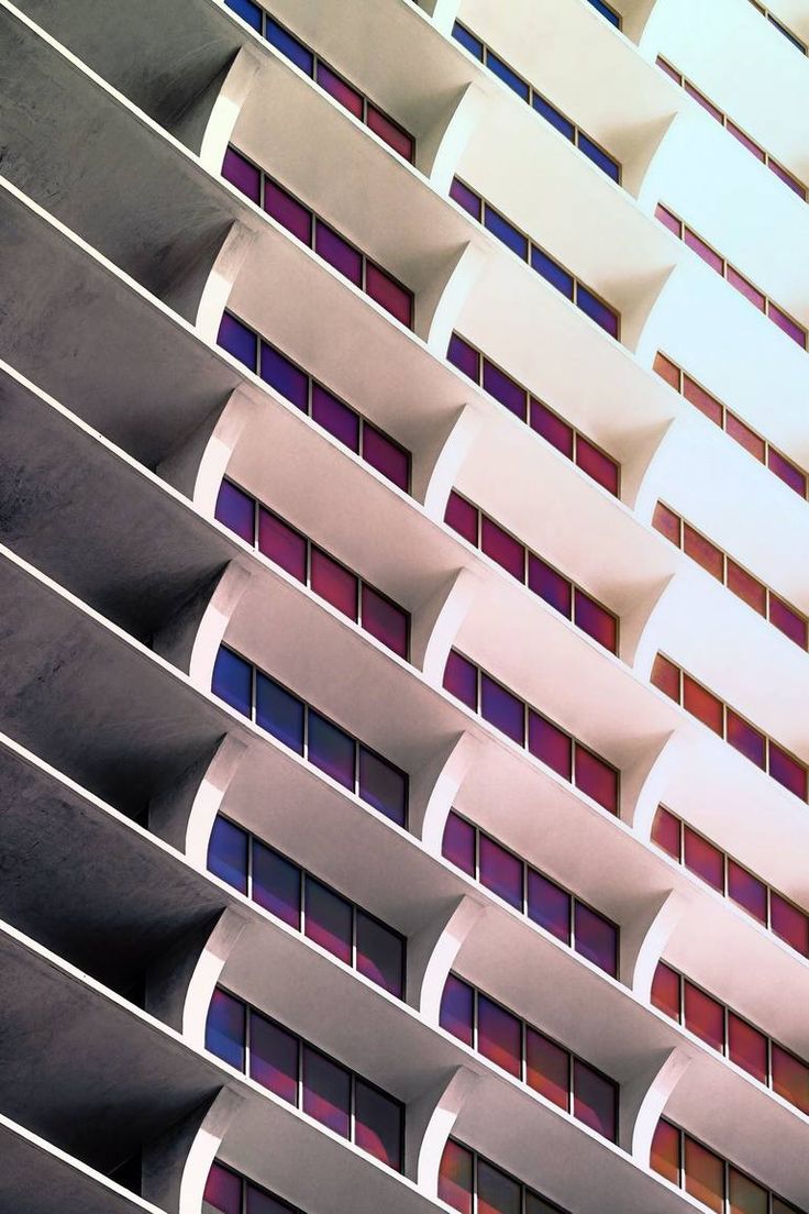 the side of a tall building with windows and balconies on it's sides