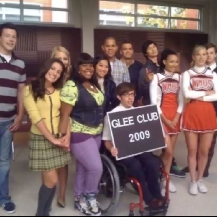 a group of young people standing next to each other in front of a sign that says glee club 2009