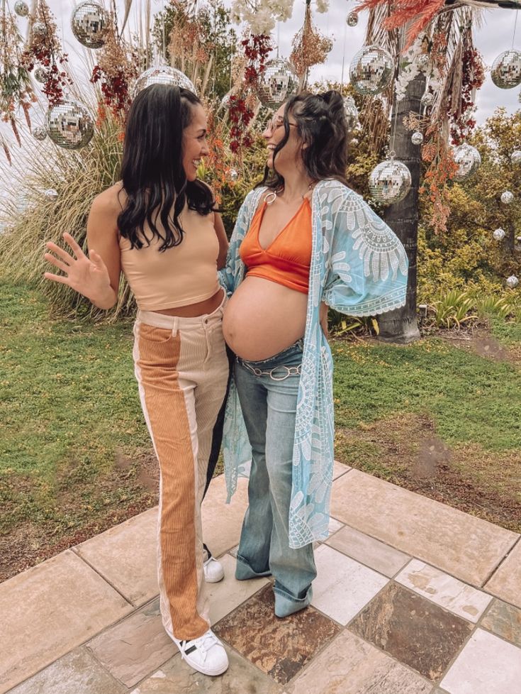 two pregnant women standing next to each other