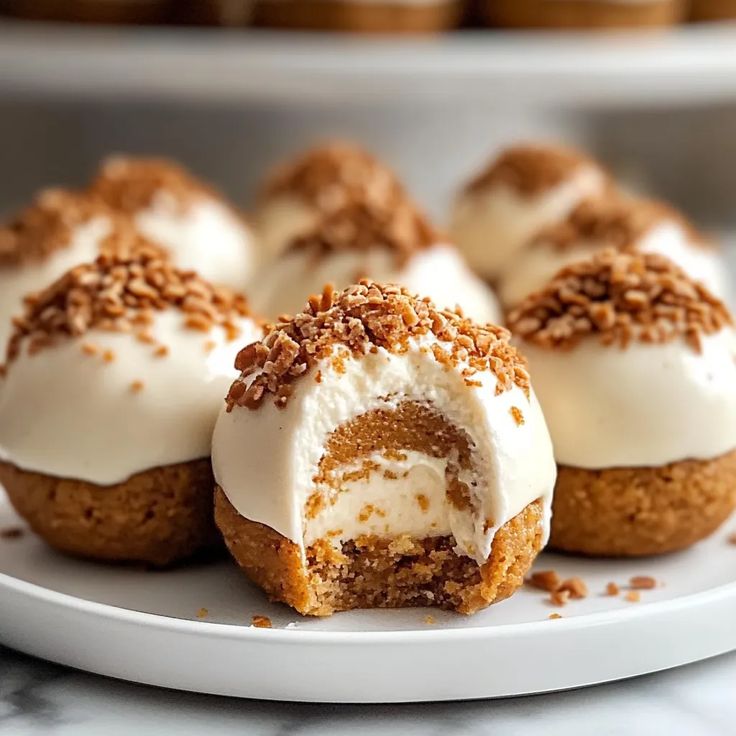 several desserts are arranged on a plate with white frosting and sprinkles