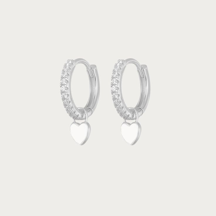 The Silver Gabby Heart Huggies are darling earrings crafted in sterling silver, featuring endearing heart-shaped accents in a classic huggie style. These earrings exude a timeless elegance with a touch of playful charm. Their sleek silver design makes them versatile, ideal for both casual and formal occasions, adding a delightful hint of love and sophistication to any ensemble. Available in various colours Hoop Size: 13mmx13mm Charm Size: 5mmx5mm Silver Plated Tarnish free / Water resistant 💧 Sterling Silver Huggie Earrings For Valentine's Day, Valentine's Day Sterling Silver Huggie Earrings, Silver Heart Charm Huggie Earrings, Silver Huggie Earrings For Valentine's Day, Silver Huggie Earrings With Heart Charm, Heart-shaped Sterling Silver Huggie Earrings For Valentine's Day, White Sterling Silver Heart Charm Earrings, Elegant Sterling Silver Heart Huggie Earrings, Elegant Heart-shaped Sterling Silver Huggie Earrings