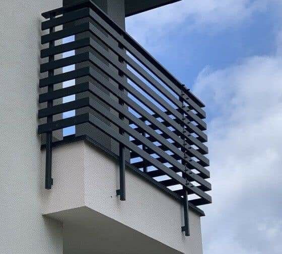 the balcony railing is made of metal and has black slats on it's sides