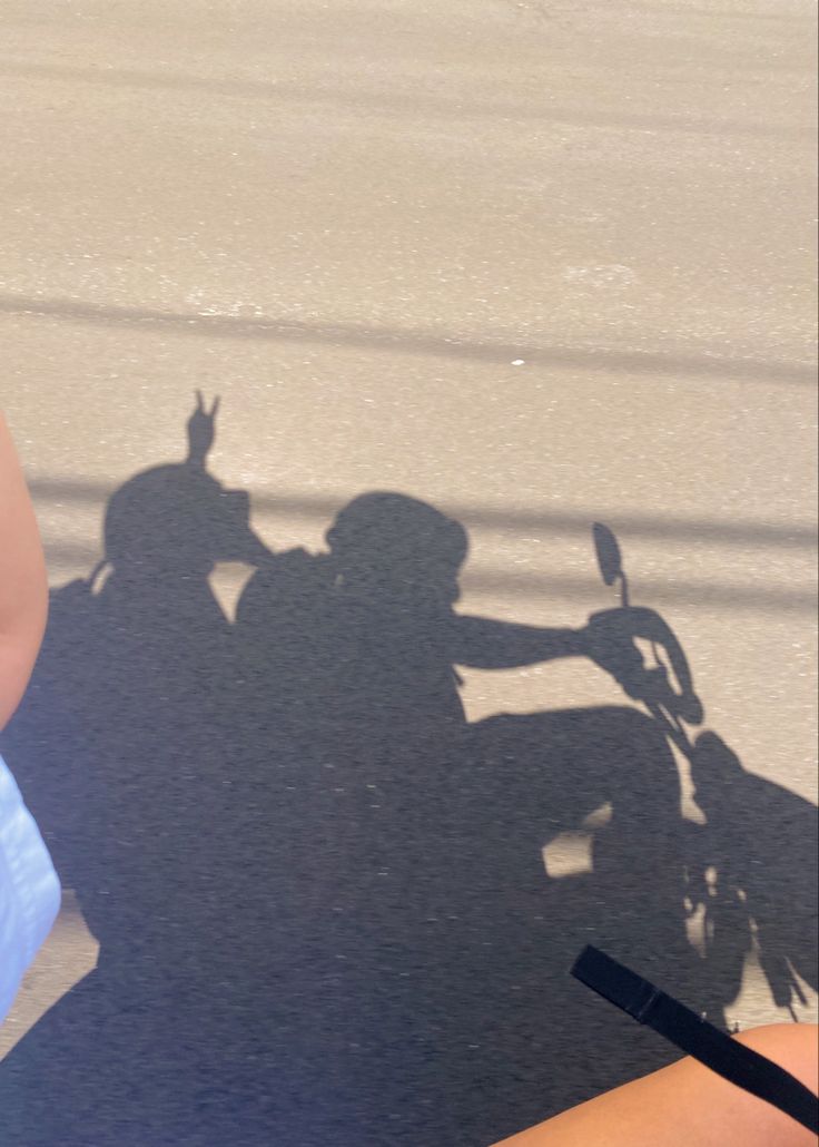 the shadow of two people on a motorcycle