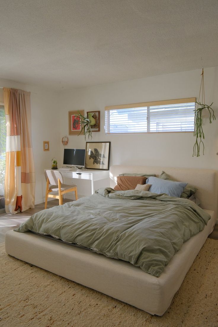 a bedroom with a bed, desk and window