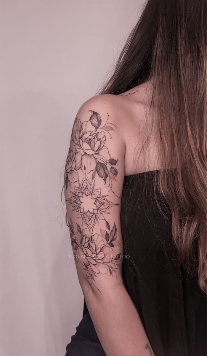 a woman with long brown hair has a tattoo on her arm and is wearing a black dress