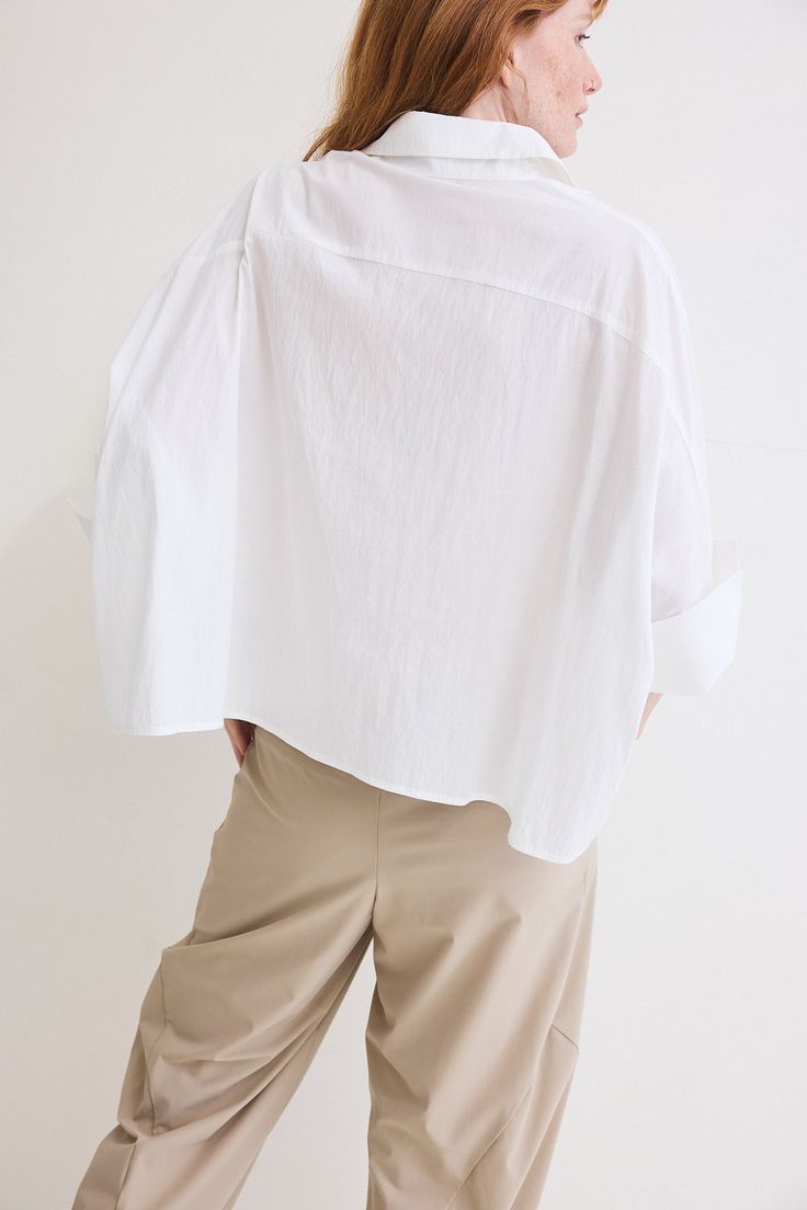 The Poplin Oversized Cropped Blouse is a contemporary twist on a classic wardrobe staple. Crafted from premium poplin fabric, this blouse effortlessly combines comfort, style, and versatility to elevate your everyday look Modern Oversized Button-up Tops, Chic Poplin Top With Relaxed Fit, Oversized Poplin Tops For Spring, Casual Poplin Blouse For Workwear, Relaxed Fit Poplin Top For Work, Chic Oversized Cotton Blouse, Modern Oversized Blouse For Office, Versatile Oversized Solid Color Blouse, Oversized Classic Cotton Blouse