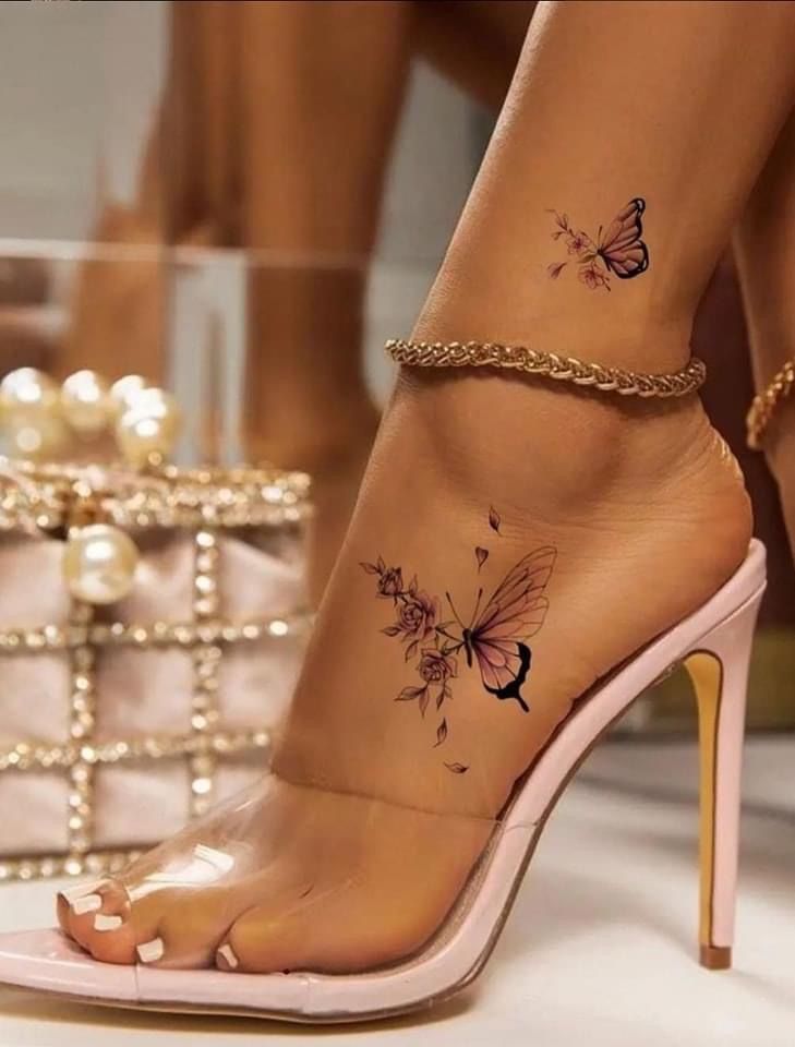 a woman's foot with butterfly tattoos on her left ankle and gold chain around the ankles