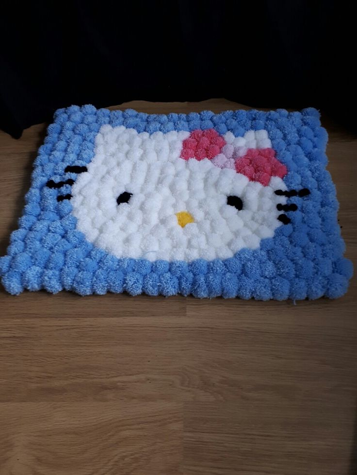 a crocheted hello kitty rug is laying on the floor