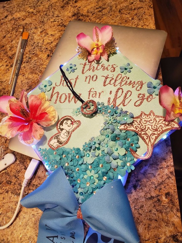 a decorated graduation cap with flowers on it sitting on top of a granite countertop