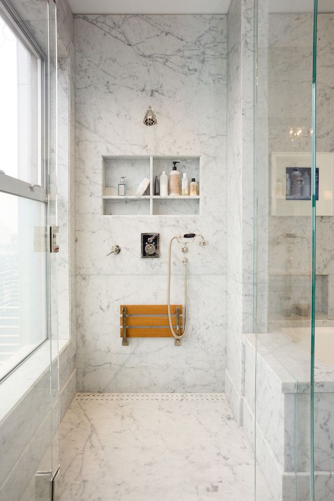 a bathroom with white marble walls and flooring on the wall is featured in an instagram