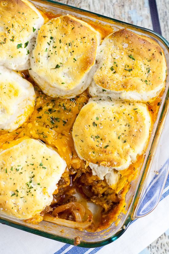 a casserole dish filled with biscuits and meat