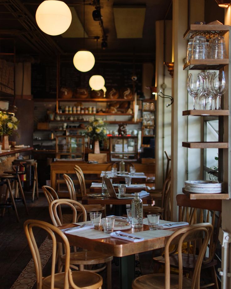 an empty restaurant with wooden tables and chairs