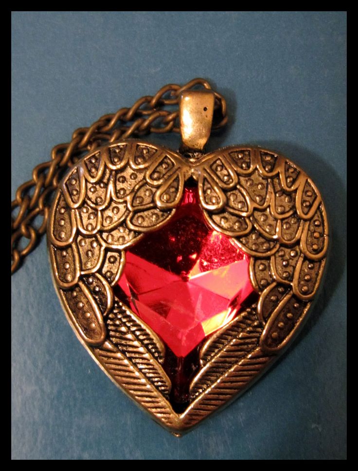 a heart shaped locke with a red stone in the center