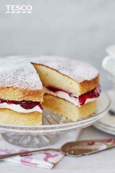 two pieces of cake sitting on top of a glass plate next to a cup and saucer