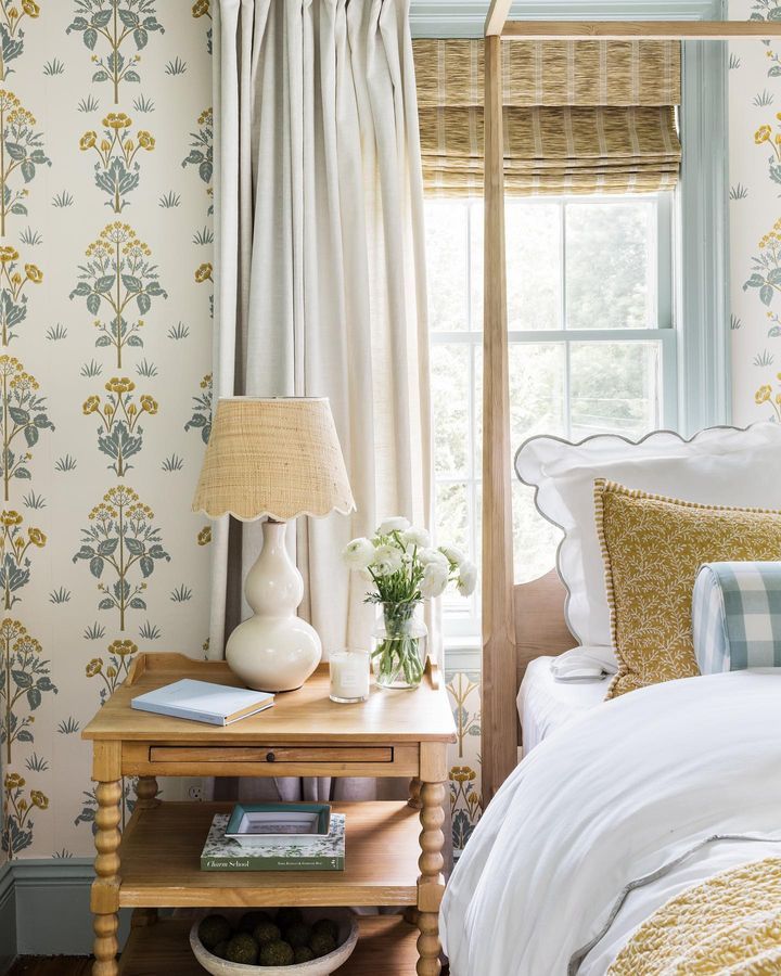 a bed room with a neatly made bed and a lamp on a table next to it