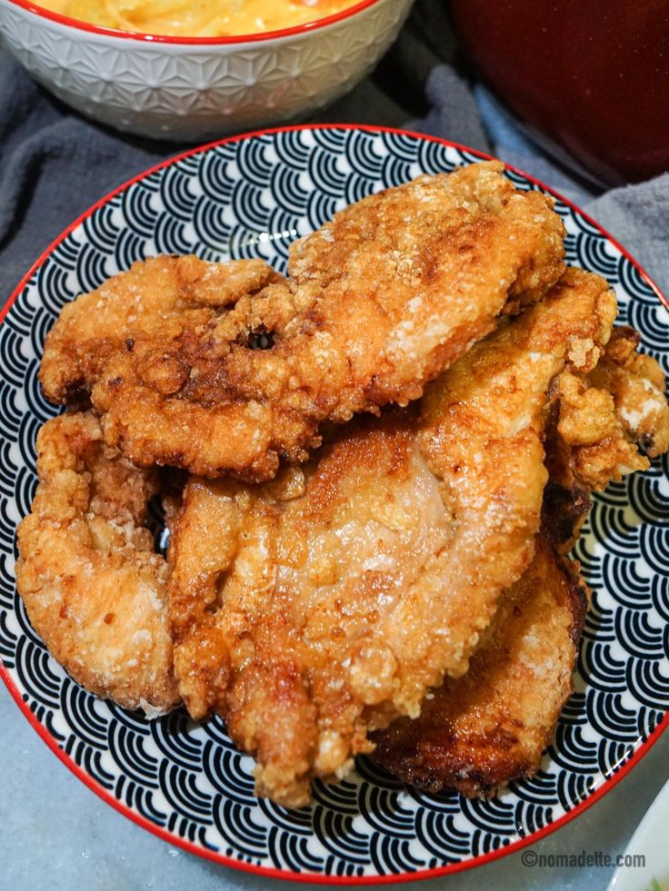 fried chicken on a plate next to a bowl of macaroni and cheese