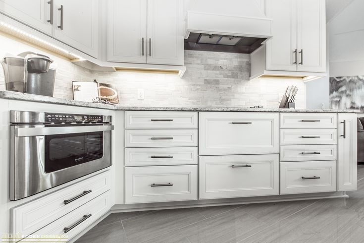 a kitchen with white cabinets and stainless steel appliances