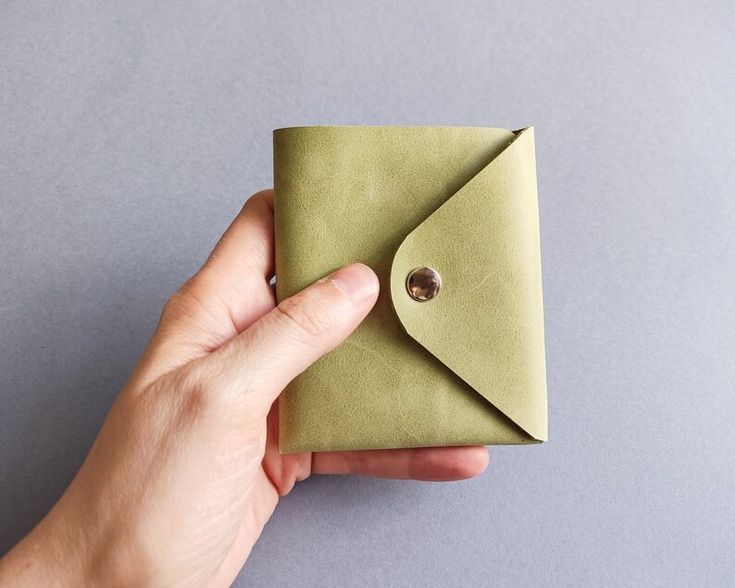 a hand is holding an envelope with a button on the front, and it's open