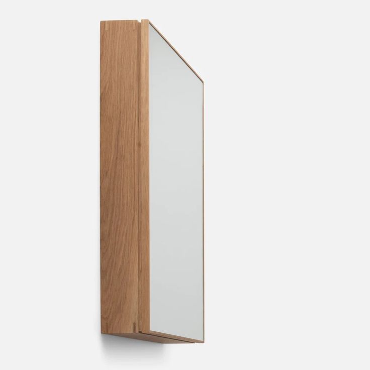 a wooden and glass cabinet against a white wall