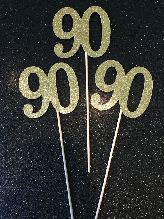 cake topper with the number 909 on it in gold glitter and white frosting