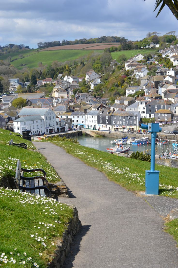 there is a bench on the side of this path next to some water and buildings