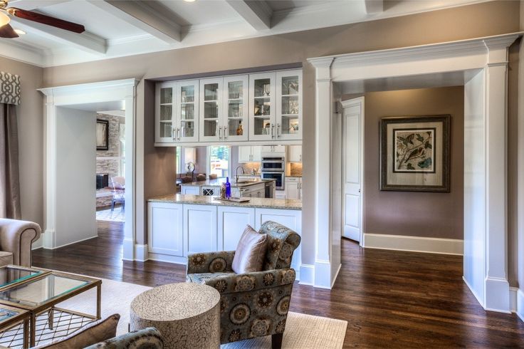 a living room filled with furniture next to a kitchen