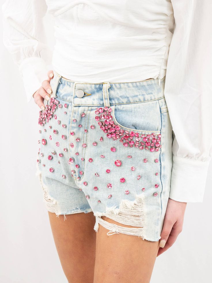 Nothing says fun like a pair of jeweled shorts. These feature pink gems across the front and boarding the front pockets. They are a high waisted style and one of our favorites. SIZE & FIT Fit is true to size Model is 5'6" wearing size small Glamorous Bottoms With Built-in Shorts, Glamorous Embellished Summer Bottoms, Glamorous Embellished Shorts, Trendy High Waisted Embellished Bottoms, Trendy High Waist Embellished Bottoms, Glamorous High-waisted Summer Shorts, Pink Embellished Bottoms For Spring, Embellished Pink Bottoms For Spring, Spring Party Jean Shorts