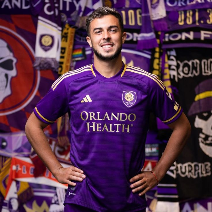 a man standing in front of a wall covered with banners