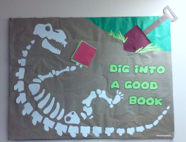 a paper bag that says, dig into a good book with a dinosaur skeleton on it