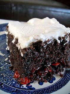 a piece of chocolate cake with white frosting on a blue and white china plate