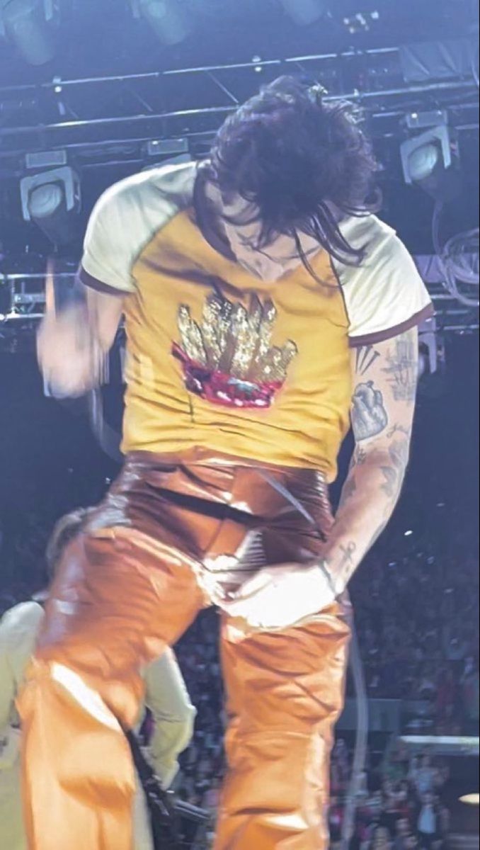 a man with long hair and piercings on his arm is performing in front of an audience