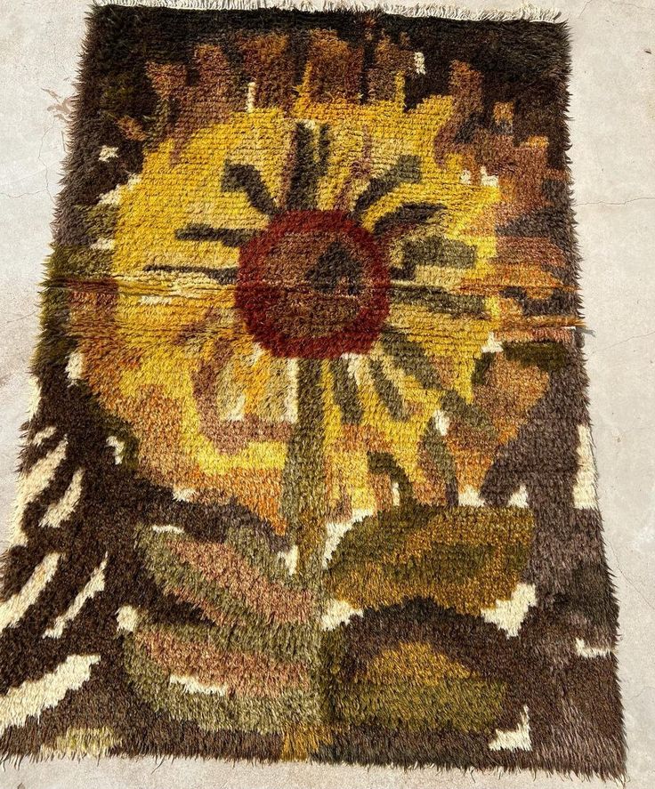 an area rug that has been placed on the floor with a flower in the center