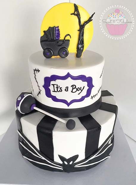 two tiered cake decorated with black, white and purple icing featuring a baby carriage