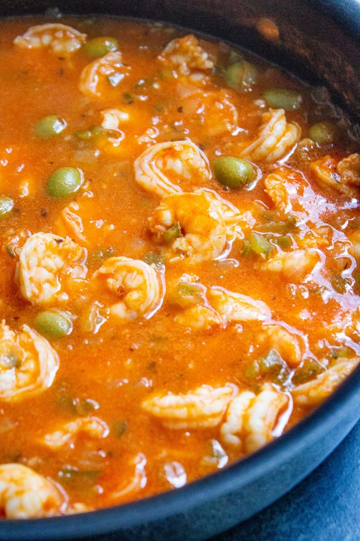 a pot filled with shrimp and vegetables on top of a table