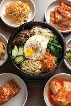 Bibimbap! Stone pot full of assorted vegetables over white rice. At the table, add an uncooked egg and stir while it cooks in the hot stone pot. I love to drench it with sesame oil and Korean chili paste lol. So good! My favorite Korean dish!!! Bim Bim Bap Recipe Korean Food, Korean Table Food, Bi Bim Bap Recipe, Bibimpab Korean, Bim Bim Bap Recipe, Korean Food Table, Bi Bim Bap, Korean Bibimbap, Korean Chili