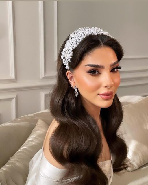 a woman with long hair wearing a tiara on top of her head sitting on a couch