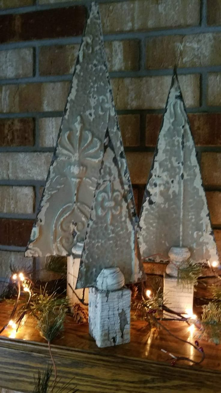 two christmas trees are sitting on a mantle