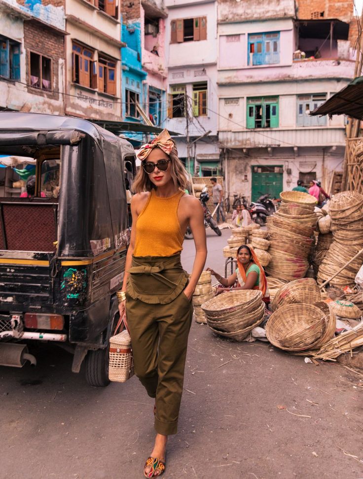 a woman is walking down the street with baskets on her head