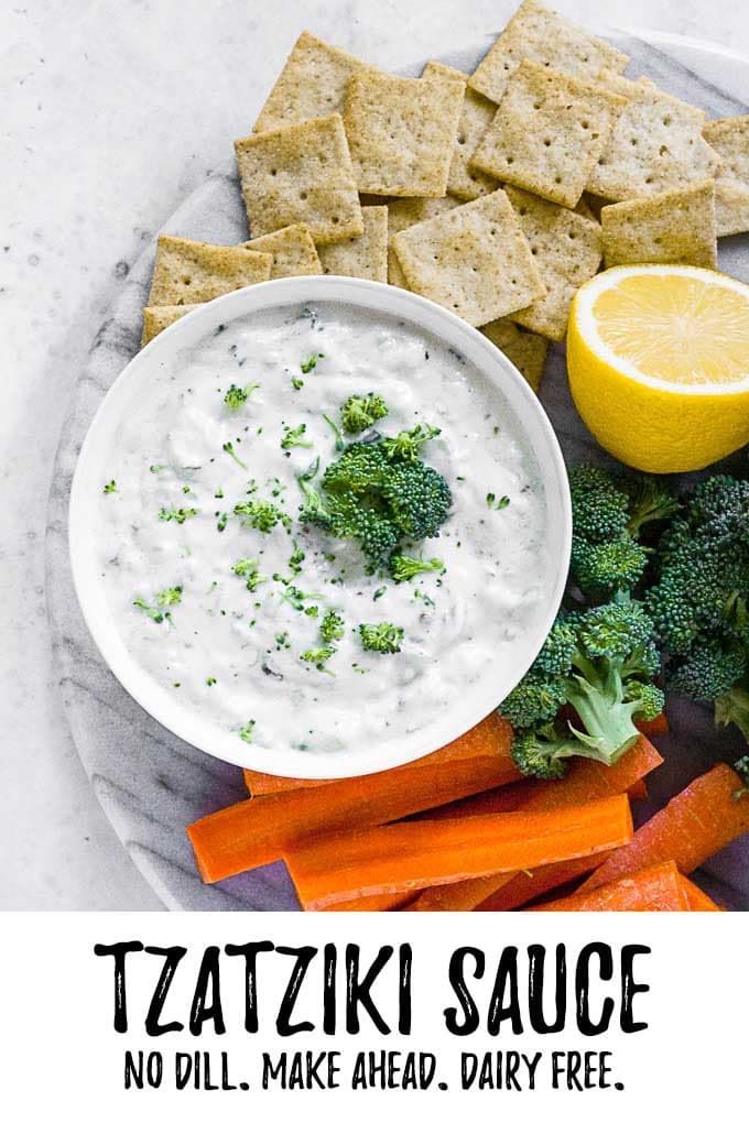 a plate with crackers, broccoli, carrots and dip on it